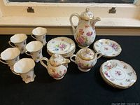 Full lot view showing cups, teapot, sugar bowl, creamer and plates