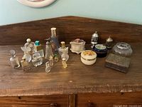 Wide view of all trinket containers and perfume bottles on wooden surface
