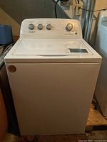 Front-facing view of the white Whirlpool top-load washing machine