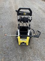 Front view of Karcher K1900 pressure washer showing hose reel, storage bin, and spray wand.