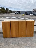 Four wooden retro cabinets arranged side by side outdoors, showing front closed doors.