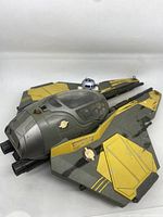 Close-up of the Anakin Yellow Jedi Starfighter showing gray and yellow paint, cockpit canopy, and R2-D2 behind cockpit.