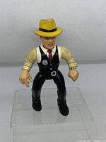 Front view of the vintage Dick Tracy figure standing with yellow hat and black vest.