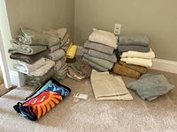 Full lot arranged on carpet with stacks of towels and wash cloths showing variety in colors and sizes.