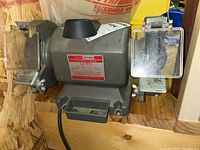 Front view of the Craftsman bench grinder showing label and grinding wheels with protective shields.
