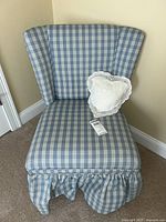 Front view of the custom upholstered occasional chair with plaid fabric and white lace heart-shaped pillow on seat.