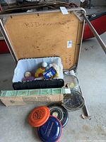 Full view of the underside of the vintage Samsonite folding card table with various sports items below