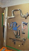 Photo of pegboard holding hand drills, staplers, woodworking planes, level and combination square