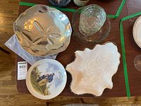 Overview photo showing all items: the silver sand dollar bowl, oyster-shaped ceramic bowl, sailor collector's plate, and stacked crystal bowls