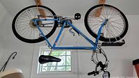 Side view of men's blue Ranger Zebra 20" bike hanging upside down showing frame, wheels, pedals, and saddle.
