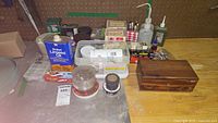 Overview of assorted items on table including boxes, cans, and a wooden box