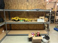 Wide view of the shelf unit with some toy trucks and boxes on it, showing overall structure and size.
