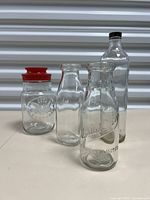 All four bottles arranged standing on a flat surface showing size and lid variety