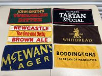 Overview photo showing all six vintage bar towels laid out flat, details of logos and text visible.