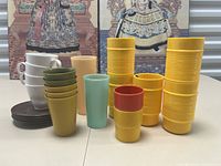 Photo showing full lot of vintage cups of various colors and brands including Tupperware, Rubbermaid, and Ingrid Chicago.
