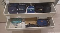 Top drawer showing five baseball caps lined up
