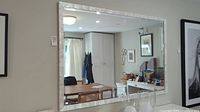 Full view of mirror hung on wall in living space, shows scale and style