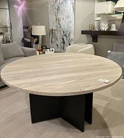 Top view of round wood-grain tabletop and black cross pedestal base