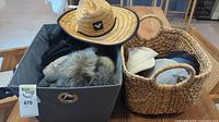 Wide view of lot showing two baskets containing multiple hats, scarves, and gloves. Natural straw hat displayed on top.