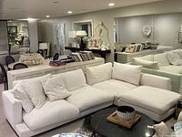 Angled view of entire off-white sectional sofa with three cushions