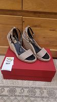 Pair of nude leather wedge espadrille sandals displayed on red Valentino box
