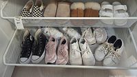 Shelf view showing ten pairs of women’s shoes: mix of sneakers, sandals, clogs, slippers.