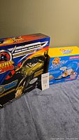 Photo showing boxed Kung Zhu Mission Control and Zhu Zhu Pets surfboard and sleep dome playsets side by side.