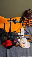 Orange dog life jacket, two SixBone dog leashes and four Halloween themed dog toys arranged on a surface