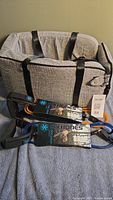 Photo showing small dog travel bed and two SixBones dog leashes, one orange and one blue