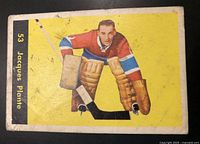 Front of vintage 1960-61 Parkhurst hockey card with image of Jacques Plante in goalie uniform on yellow background with card number and name on left edge.