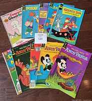 Top view of the 10 Gold Key comic books stacked and fanned out on a wooden surface showing colorful covers with cartoon characters.