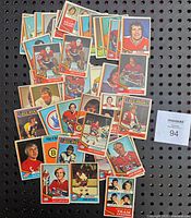 Lot of 1974-75 O.P.C. hockey cards displayed in overlapping arrangement showing front images of players including Tony Esposito, Guy Lafleur, Denis Potvin, and others.