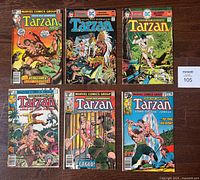 Photo showing six vintage Tarzan comic books from Marvel and DC laid flat on table, with titles and artwork visible.