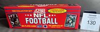 Original red factory box for 1990 Score NFL Football card set, showing front and side with text indicating 665 player cards and 5 bonus cards.