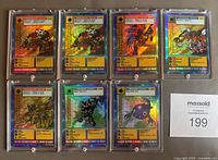 Front view of seven Digimon trading cards in protective plastic sleeves, showing character artwork and holofoil design.