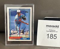 Front view of the Denny Martinez 1992 Topps Montreal Expos baseball card showing player image and signature in blue Sharpie, encased in plastic protector, beside MaxSold auction number.