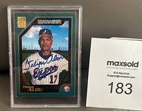 Front view of Felipe Alou 2000 Topps baseball card signed in blue Sharpie, encased in plastic sleeve.