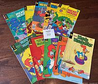 10 comic books arranged on floor, 5 Woody Woodpecker and 5 Mickey Mouse and Goofy from Gold Key and Whitman, showing front covers with colorful illustrations and minor wear.