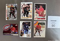 Photo showing 6 autographed NHL hockey cards including Brad Marsh, Rick Tocchet, Rick Bowness, Yvan Cournoyer, Doug Gilmour, and Gary Roberts.