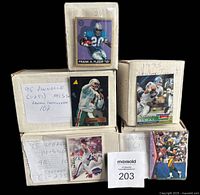 Five cardboard boxes containing different near complete NFL football card sets from mid-1990s with player images on box ends.