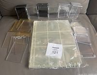 Lot contents arranged on couch including plastic boxes, soft holders, screw down holders, and unopened 9 card sheets