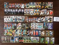 Photo showing a large assortment of 1995 NFL football trading cards spread out on a surface, featuring various players and card types.