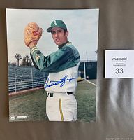 Full 8 x 10 color photo of Rollie Fingers in Oakland A's baseball uniform on the field, showing the autograph.