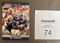 Front side of the 1990 Pro Set Troy Aikman football card featuring a blue Sharpie autograph across the player image in Cowboys uniform.