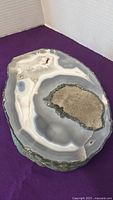 Top view of the polished agate slice showing the central geode and layered bands.