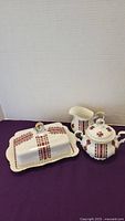 Porcelain cream and sugar set with butter dish showing floral red pattern and gold trim on white background