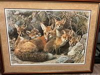 Framed print showing fox family in a rocky natural setting with four fox kits and an adult fox.