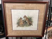 Framed print of two fox puppies playing, showing full artwork and frame.