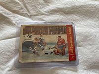 Photo of 1955-56 Quaker Oats hockey card number 75 depicting Leaf Speedsters Attack on the ice including J Plante. Card condition shows creases and wear.