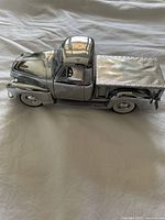 Side angle of chrome finished 1949 Chevy pickup model showing cab and bed details